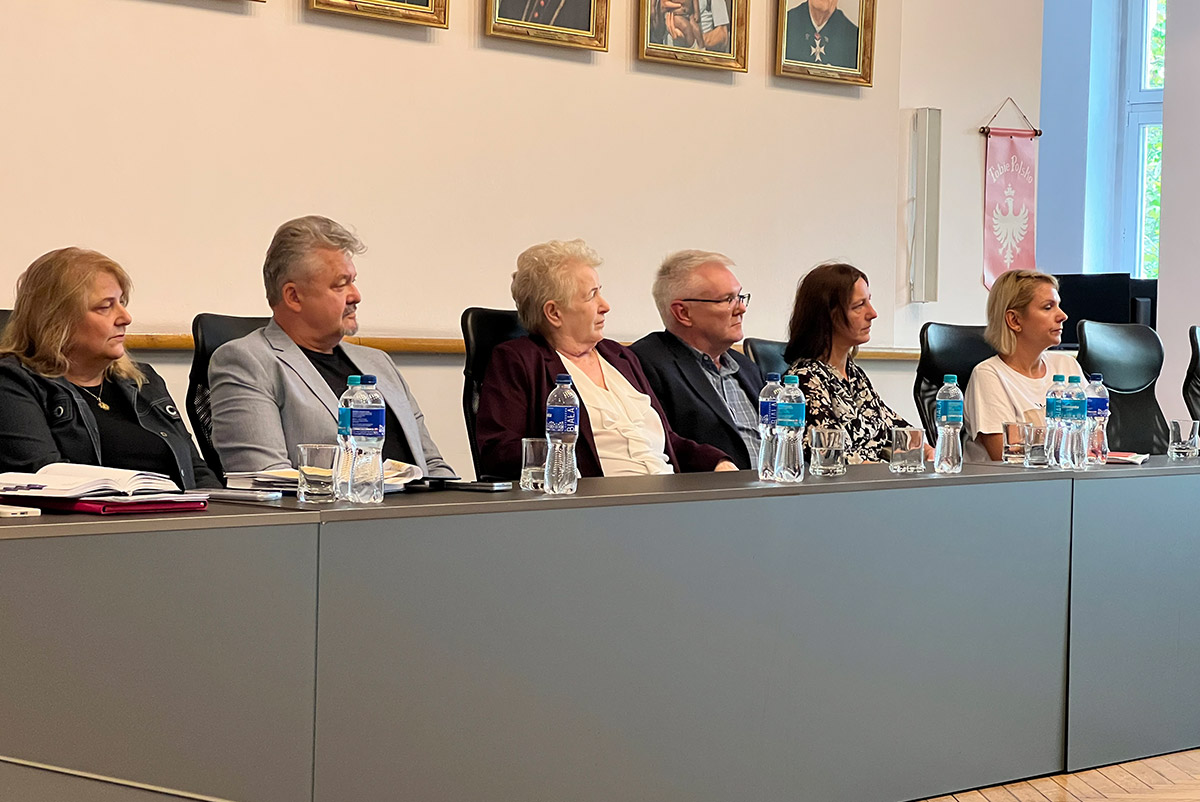 Uczestnicy spotkania projektu „REgeneracja Miast” podczas obrad przy stole konferencyjnym.