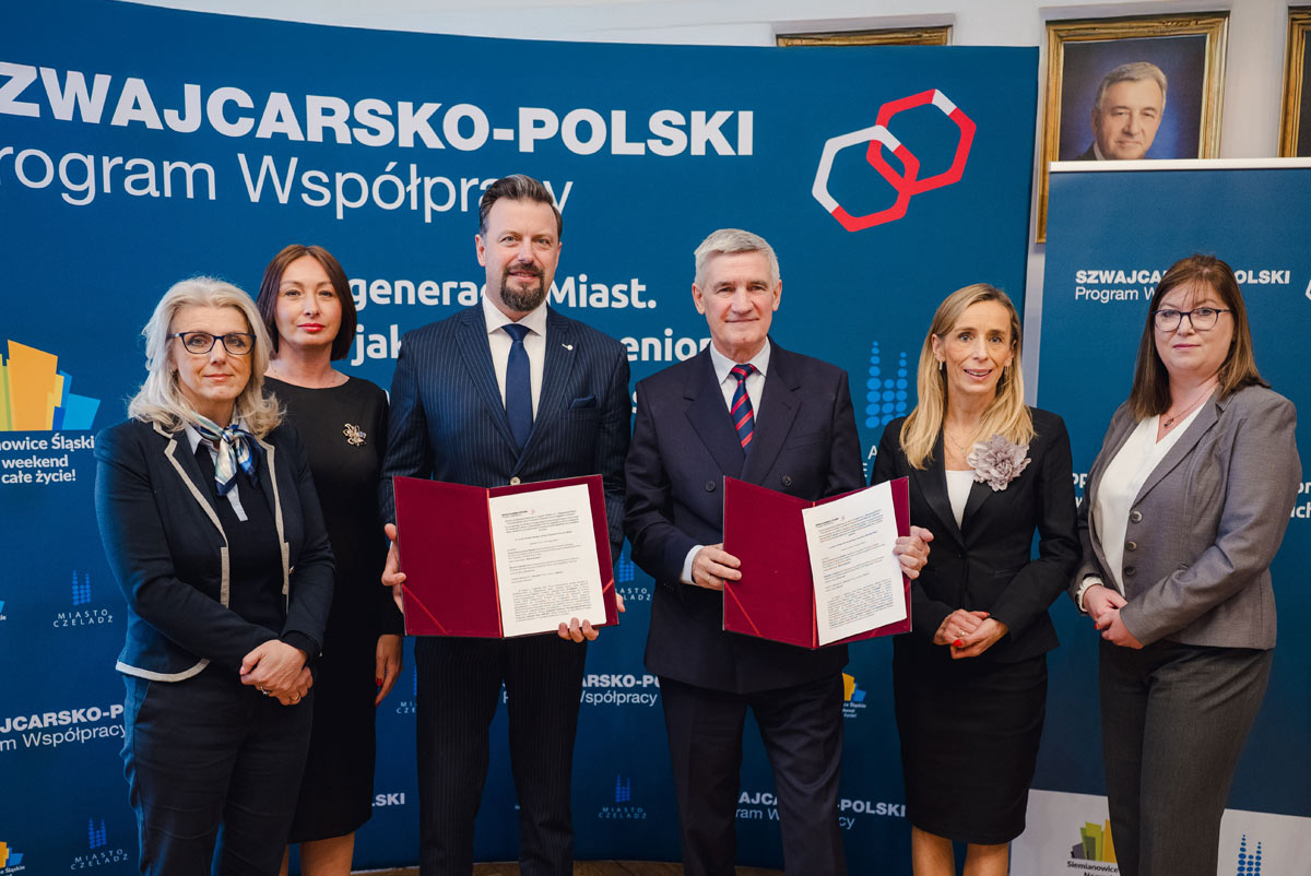 Rafał Piech, Agnieszka Gładysz, Katarzyna Chrapek-Rogowska, Zbigniew Szaleniec, Małgorzata Skiba oraz Bogusława Tanhojzer trzymający podpisane dokumenty na tle ścianki z logo Szwajcarsko-Polskiego Programu Współpracy.