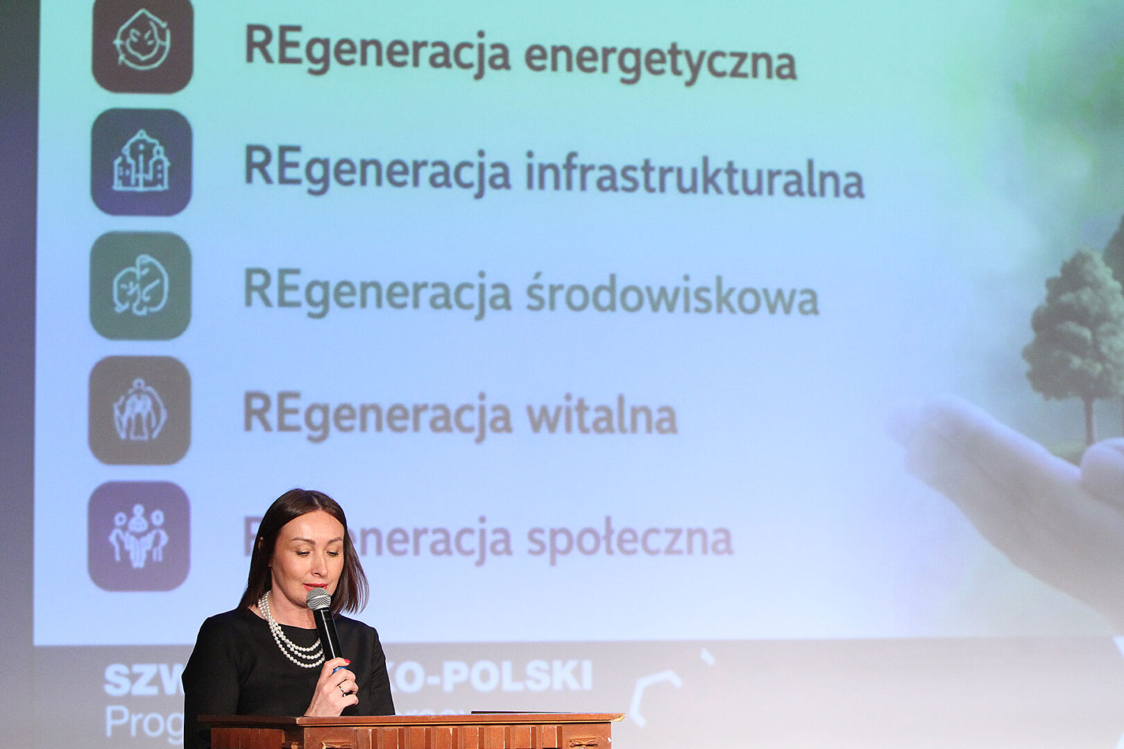 Kobieta opowiada o REgeneracji Miast z mównicy.